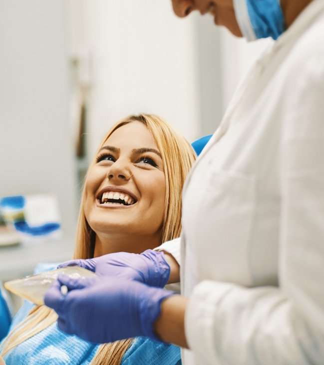 Woman laughing with dentist during cosmetic dentistry treatment